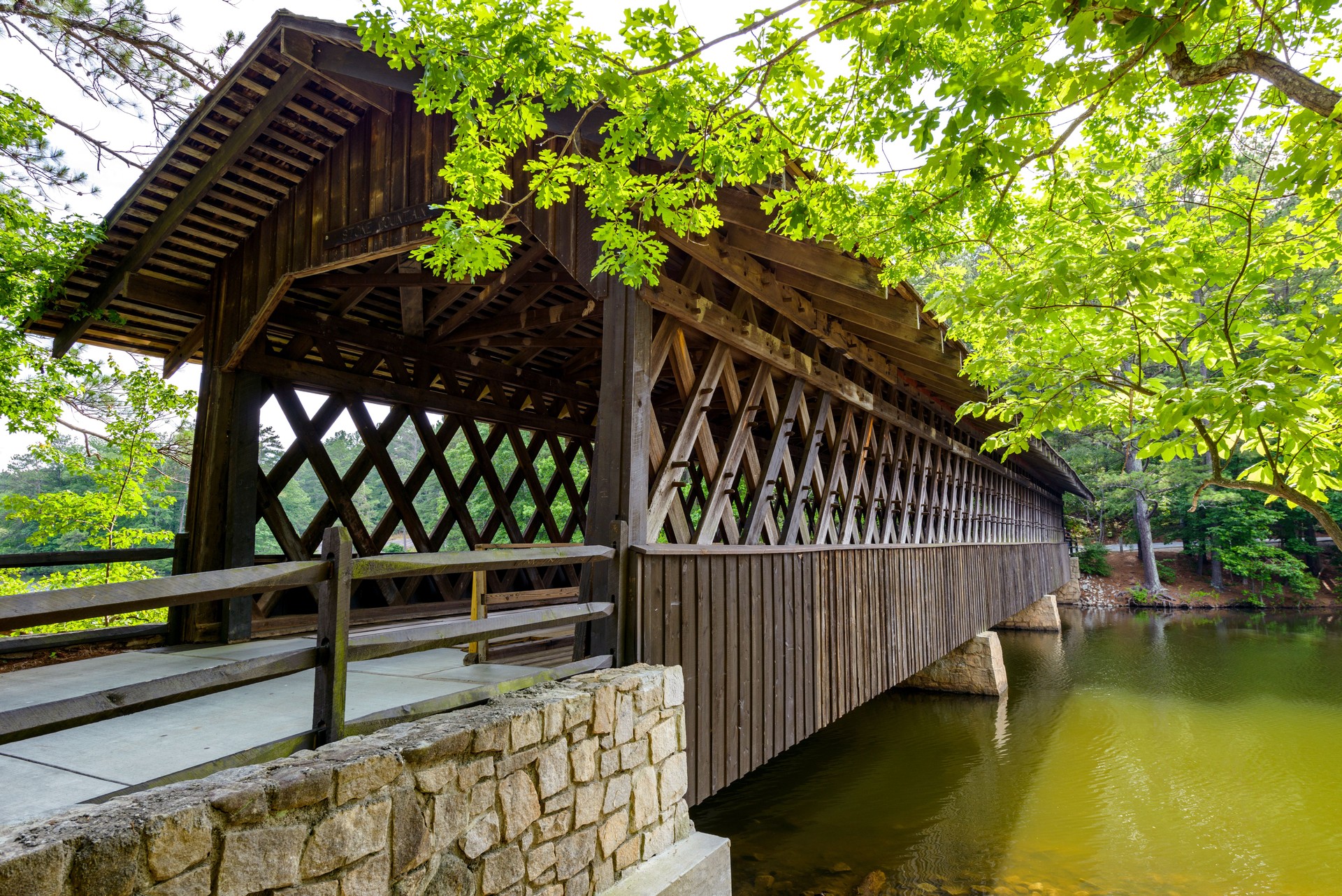 A close-up side view of a century old wood Covered Bridge in Stone Mountain State Park, Atlanta, Georgia, USA.